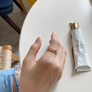 Close-up of a double-layered gold ring on a finger with a modern minimalist open design
