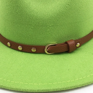 Detail of wool felt fedora texture with brown leather band and gold buckle detail
