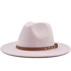 Detail of light pink fedora hat featuring a brown leather band with golden rivets