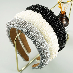 Detail of beaded wide headbands with faux pearls and velvet lining on a gold stand