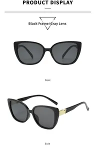 Detail of square oversized sunglasses featuring black frames and golden V-shaped metal accents