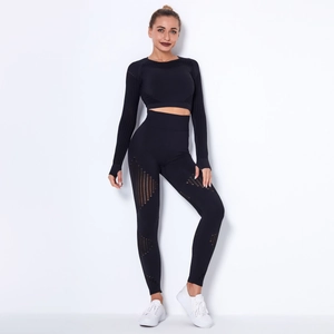 Dettaglio del motivo a strisce traforate su top yoga nero a maniche lunghe e leggings
