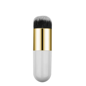 Detail of soft synthetic bristles and gold ferrule of a dual-use makeup brush