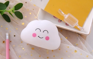 Cute white silicone cloud night light with smiley face on a decorative star fabric backdrop