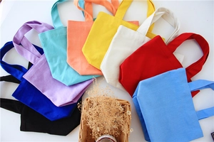 Various colors of canvas lunch bags displayed in a fan-shaped arrangement with natural props