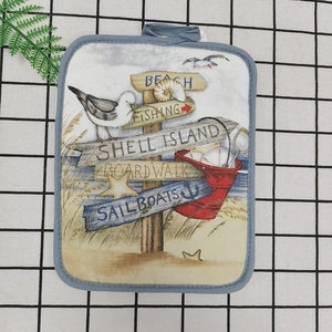 Detail of nautical thick cotton heat resistant mat with beach scenery and hanging loop