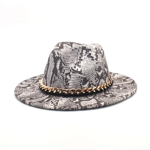 Dettaglio cappello in lana a serpente con nastro decorativo a catena dorata