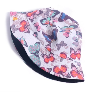 Detailed close-up of white bucket hat featuring colorful butterfly prints and black lining