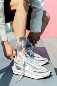 Close-up of Nike x Sacai LDV Waffle tie-dye socks worn with white and grey sneakers