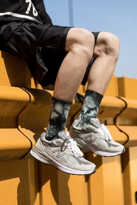 Close-up of stylish grey tie-dye mid-calf socks paired with classic running sneakers