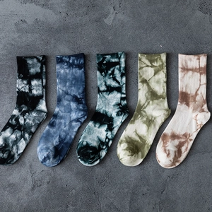 Five pairs of tie-dye cotton crew socks in diverse colors displayed on a concrete floor
