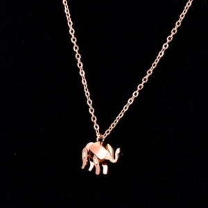 Rose gold elephant pendant necklace with delicate chain on a black background