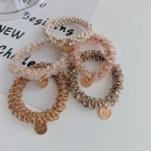 Five-piece set of pearl and crystal beaded elastic hair ties with gold handmade charms