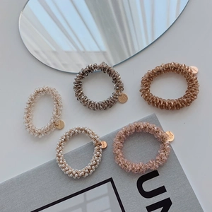Detailed macro view of 5-piece crystal bead hair ties with handmade metal charms