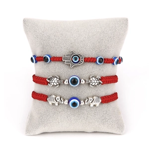 Three-piece red braided evil eye bracelet set with hamsa hand, elephant and turtle charms