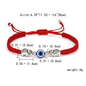 Detail view of adjustable red woven Evil Eye bracelet with silver elephant charms and beads