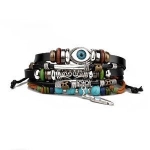 Macro detail of multi-layer leather bracelet featuring turquoise beads and evil eye charm