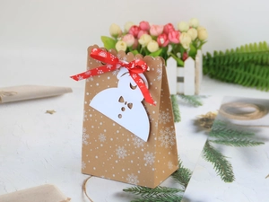 Details von Kraftpapier-Weihnachtsbeutel mit Schneeflocken und rotem Band