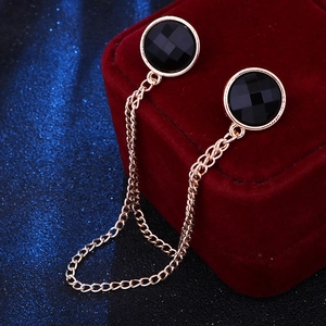 Detailed close-up of golden collar chain with black round faceted gemstones on red velvet
