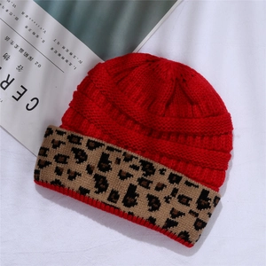 Detailed view of red knitted beanie with thick leopard print cuff and ribbed texture
