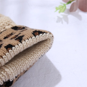 Detailed macro view of leopard print acrylic knit fabric with dense stitching texture