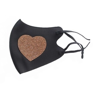 Detail of a black fabric face mask featuring a brown rhinestone heart and adjustable ear loops