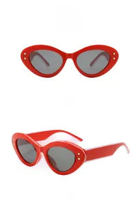 Détails de lunettes de soleil œil-de-chat rouges avec étoiles dorées et verres gris