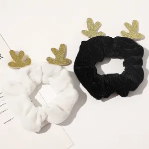 Detail of Christmas reindeer antler hair scrunchies in black and white velvet textures