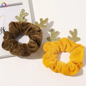 Christmas velvet scrunchies with sequined reindeer antlers in brown and yellow colors