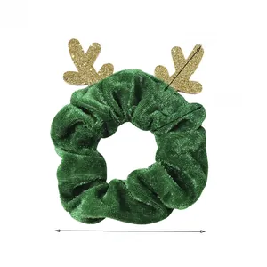 Detail view of green velvet Christmas scrunchie with golden sequin reindeer antlers