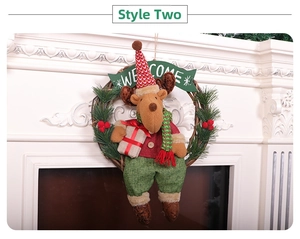 Close-up of reindeer plush sitting on a grapevine wreath with pine needles and berries