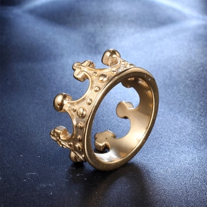 Macro shot of gold-plated crown ring detail on a textured dark blue surface
