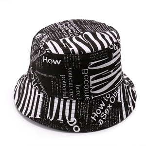 Detail of cotton canvas bucket hat featuring black and white newspaper typography print