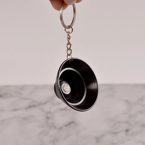 Detail view of mini black matte metal funnel keychain with silver edge finish