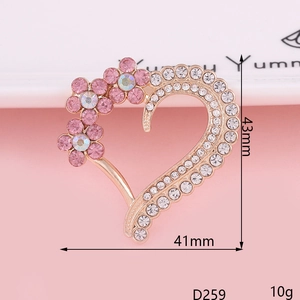 Close-up of heart-shaped alloy brooch with pink petals, rhinestones and size measurements