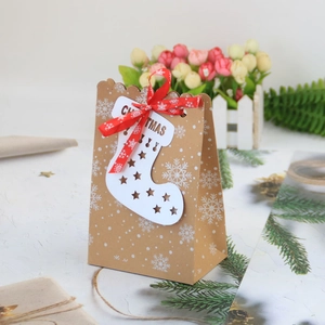 Sacchetto regalo di Natale in carta kraft con fiocchi di neve, carta calzino e nastro rosso