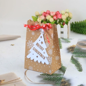 Sacchetti regalo di Natale in carta kraft con nastro rosso e ciondolo Merry Christmas