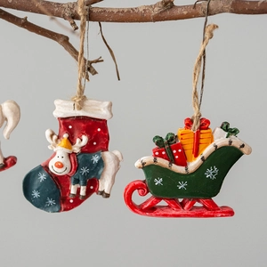 Christmas resin ornaments featuring reindeer in red sock and green sleigh on wooden branch