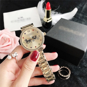 Detail of luxury gold watch with crystal bezel and champagne dial beside a gift box