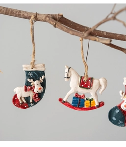Detail of resin Christmas ornaments with reindeer and rocking horse on wooden branch
