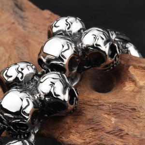 Vintage stainless steel skull bracelet for men in gothic punk style on a wood block