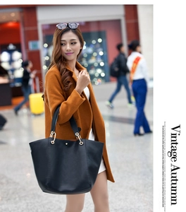 Fashionable black large capacity leather tote bag with gold hardware shown on a model