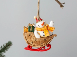 Macro detail of a resin snowman on a red sleigh Christmas ornament with rustic hemp rope