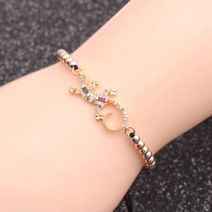 Bracelet gecko serti de zircons colorés et perles tricolores sur le poignet d'un mannequin