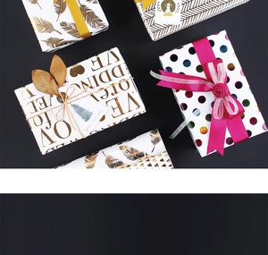 Detail of festive wrapping paper with gold feather, dot, and wedding patterns