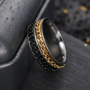 Macro shot of men's titanium steel ring with rotating black and gold double chain detail