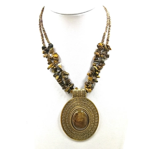 Detailed view of vintage bronze pendant necklace with brown turquoise stone and beaded chain
