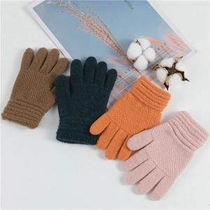 Flat lay of colorful winter knitted gloves in brown, teal, orange, and light pink