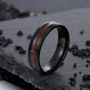 Macro detail of 6mm black stainless steel ring featuring dark koa wood grain inlay