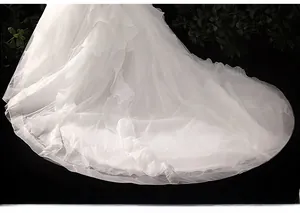 Detail of layered white tulle wedding dress with sparkling sequins and ruffled hemline